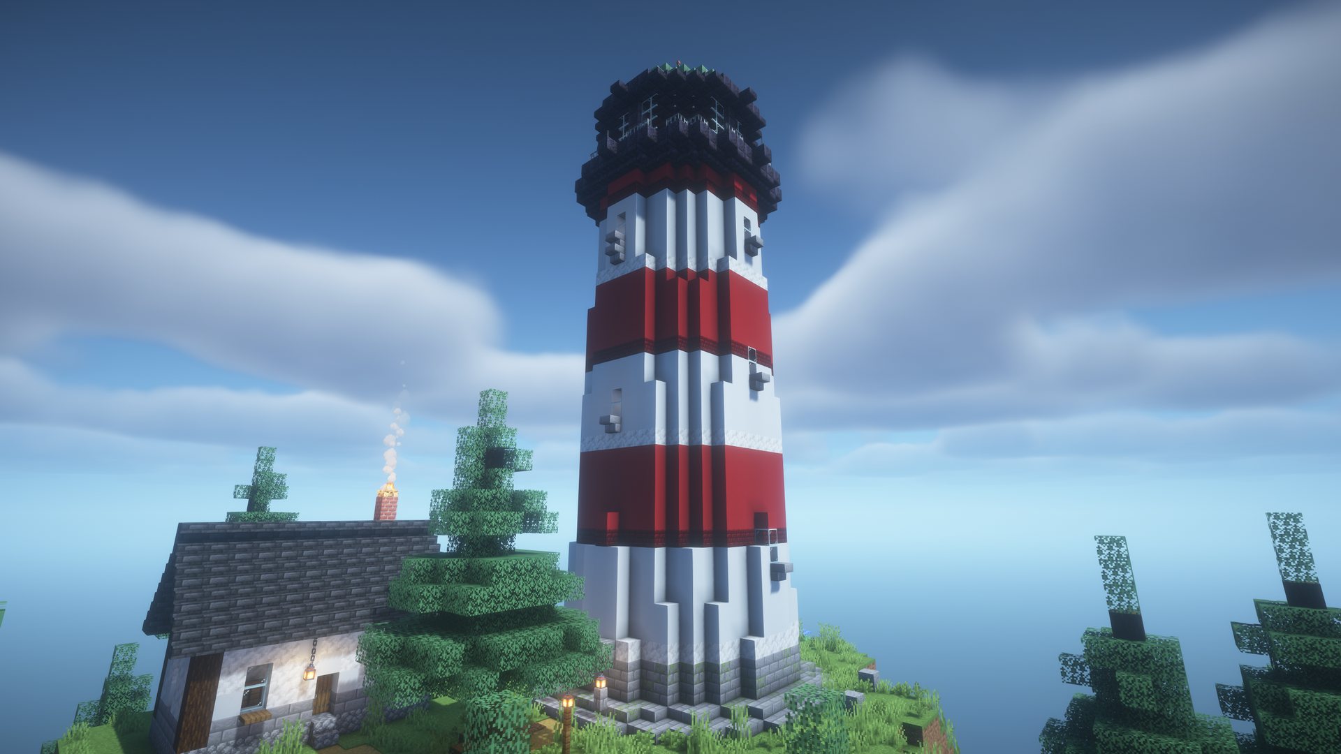 A red and white striped lighthouse next to a keeper's cottage among pine trees